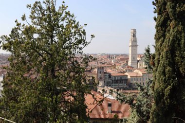 Verona, İtalya-19 Mart 2022: Verona 'nın güzel eski binaları. Ortaçağ 'ın tipik mimarisi. Arka planda mavi gökyüzü olan şehre doğru hava manzarası, nehre ulaşmak için güzel bir manzara..