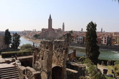 Verona, İtalya-19 Mart 2022: Verona 'nın güzel eski binaları. Ortaçağ 'ın tipik mimarisi. Arka planda mavi gökyüzü olan şehre doğru hava manzarası, nehre ulaşmak için güzel bir manzara..