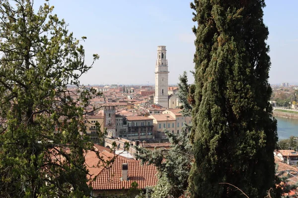 Verona, İtalya-19 Mart 2022: Verona 'nın güzel eski binaları. Ortaçağ 'ın tipik mimarisi. Arka planda mavi gökyüzü olan şehre doğru hava manzarası, nehre ulaşmak için güzel bir manzara..