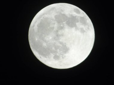 Genova, Italy -May 15, 2022: An amazing photography of the full moon over the city of Genova by night with a great clear sky in background and some stars