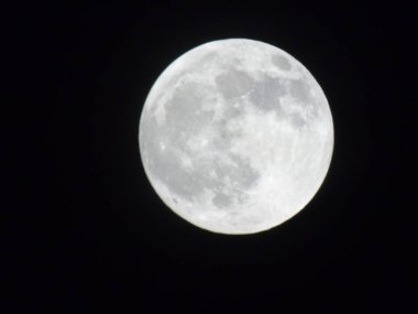 Genova, Italy -May 15, 2022: An amazing photography of the full moon over the city of Genova by night with a great clear sky in background and some stars