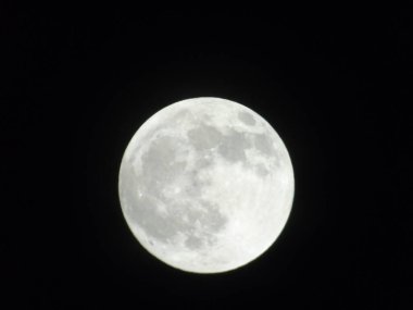 Genova, Italy -May 15, 2022: An amazing photography of the full moon over the city of Genova by night with a great clear sky in background and some stars