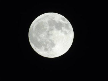 Genova, Italy -May 15, 2022: An amazing photography of the full moon over the city of Genova by night with a great clear sky in background and some stars