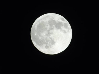 Genova, Italy -May 15, 2022: An amazing photography of the full moon over the city of Genova by night with a great clear sky in background and some stars