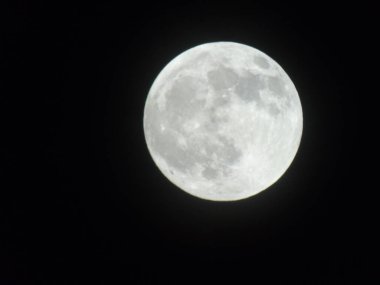 Genova, Italy -May 15, 2022: An amazing photography of the full moon over the city of Genova by night with a great clear sky in background and some stars
