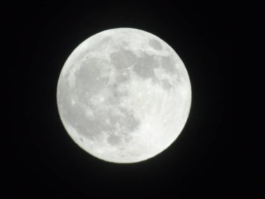 Genova, Italy -May 15, 2022: An amazing photography of the full moon over the city of Genova by night with a great clear sky in background and some stars