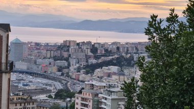 Cenova, İtalya - 07 Mayıs 2022: Denizden eski kente ve güzel gün batımına sahip limana panoramik manzara. Ceneviz Körfezi, Liman, Piercing.Turistik bölgelerde yat.