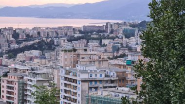 Cenova, İtalya - 07 Mayıs 2022: Denizden eski kente ve güzel gün batımına sahip limana panoramik manzara. Ceneviz Körfezi, Liman, Piercing.Turistik bölgelerde yat.