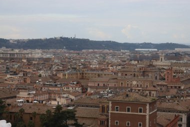 ROME, ITALY - 05 Şubat 2022: Roma, İtalya 'daki Colosseum çevresindeki panoramik manzara. Arka planda soğuk ve gri gökyüzü. Eski binalarla yeşil parkların makro fotoğrafları..