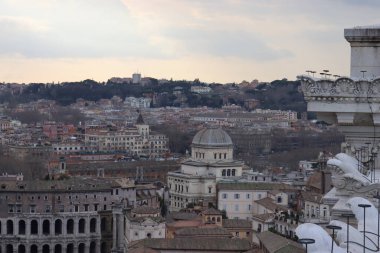 ROME, ITALY - 05 Şubat 2022: Roma, İtalya 'daki Colosseum çevresindeki panoramik manzara. Arka planda soğuk ve gri gökyüzü. Eski binalarla yeşil parkların makro fotoğrafları..