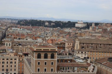 ROME, ITALY - 05 Şubat 2022: Roma, İtalya 'daki Colosseum çevresindeki panoramik manzara. Arka planda soğuk ve gri gökyüzü. Eski binalarla yeşil parkların makro fotoğrafları..