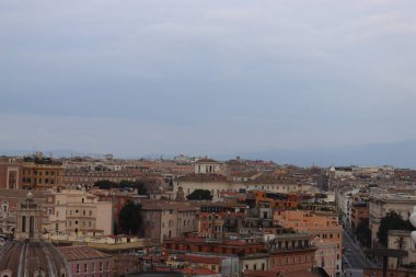 ROME, ITALY - 05 Şubat 2022: Roma, İtalya 'daki Colosseum çevresindeki panoramik manzara. Arka planda soğuk ve gri gökyüzü. Eski binalarla yeşil parkların makro fotoğrafları..