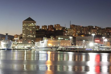 Cenova, İtalya - 02 Temmuz 2022: Geceleri şehrin ve eski limanın (Porto Antico) manzarası. Şehir ışıkları suyun üzerinde yansıyor.. 