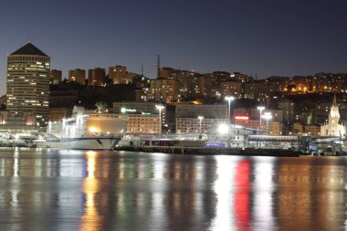 Cenova, İtalya - 02 Temmuz 2022: Geceleri şehrin ve eski limanın (Porto Antico) manzarası. Şehir ışıkları suyun üzerinde yansıyor.. 