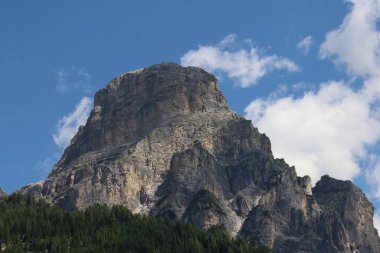 Coravara, Italy-July 16, 2022: The italian Dolomites behind the small village of Corvara in summer days with beaitiful blue sky in the background. Green nature in the middle of the rocks. 