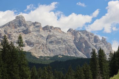 Coravara, Italy-July 16, 2022: The italian Dolomites behind the small village of Corvara in summer days with beaitiful blue sky in the background. Green nature in the middle of the rocks. 