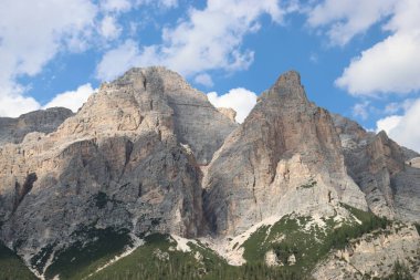 Coravara, Italy-July 16, 2022: The italian Dolomites behind the small village of Corvara in summer days with beaitiful blue sky in the background. Green nature in the middle of the rocks. 