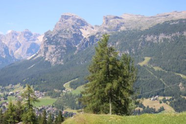 Val Badia, Italy-July 17, 2022: The italian Dolomites behind the small village of Corvara in summer days with beaitiful blue sky in the background. Green nature in the middle of the rocks.