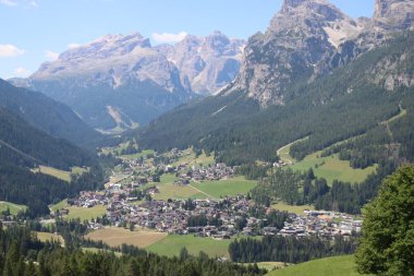 Val Badia, Italy-July 17, 2022: The italian Dolomites behind the small village of Corvara in summer days with beaitiful blue sky in the background. Green nature in the middle of the rocks.