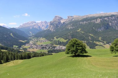 Val Badia, Italy-July 17, 2022: The italian Dolomites behind the small village of Corvara in summer days with beaitiful blue sky in the background. Green nature in the middle of the rocks.