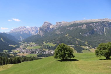 Val Badia, Italy-July 17, 2022: The italian Dolomites behind the small village of Corvara in summer days with beaitiful blue sky in the background. Green nature in the middle of the rocks.