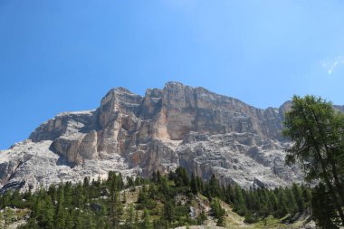 Val Badia, Italy-July 17, 2022: The italian Dolomites behind the small village of Corvara in summer days with beaitiful blue sky in the background. Green nature in the middle of the rocks.