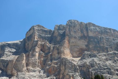 Val Badia, Italy-July 17, 2022: The italian Dolomites behind the small village of Corvara in summer days with beaitiful blue sky in the background. Green nature in the middle of the rocks.