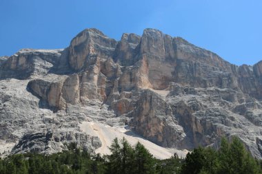 Val Badia, Italy-July 17, 2022: The italian Dolomites behind the small village of Corvara in summer days with beaitiful blue sky in the background. Green nature in the middle of the rocks.