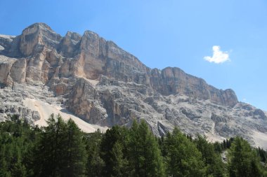 Val Badia, Italy-July 17, 2022: The italian Dolomites behind the small village of Corvara in summer days with beaitiful blue sky in the background. Green nature in the middle of the rocks.