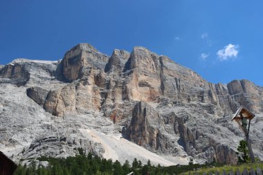 Val Badia, Italy-July 17, 2022: The italian Dolomites behind the small village of Corvara in summer days with beaitiful blue sky in the background. Green nature in the middle of the rocks.