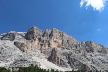 Val Badia, Italy-July 17, 2022: The italian Dolomites behind the small village of Corvara in summer days with beaitiful blue sky in the background. Green nature in the middle of the rocks.