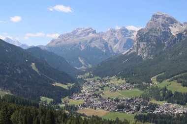 Val Badia, Italy-July 17, 2022: The italian Dolomites behind the small village of Corvara in summer days with beaitiful blue sky in the background. Green nature in the middle of the rocks.