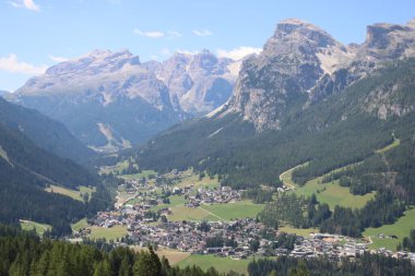 Val Badia, Italy-July 17, 2022: The italian Dolomites behind the small village of Corvara in summer days with beaitiful blue sky in the background. Green nature in the middle of the rocks.