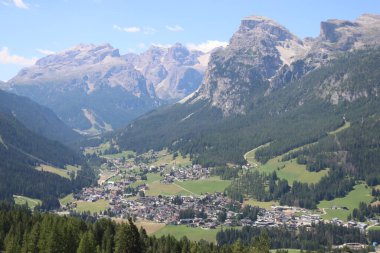 Val Badia, Italy-July 17, 2022: The italian Dolomites behind the small village of Corvara in summer days with beaitiful blue sky in the background. Green nature in the middle of the rocks.