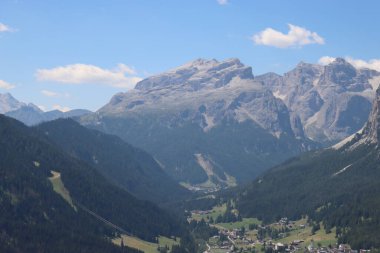 Val Badia, Italy-July 17, 2022: The italian Dolomites behind the small village of Corvara in summer days with beaitiful blue sky in the background. Green nature in the middle of the rocks.