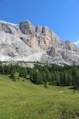 Val Badia, Italy-July 17, 2022: The italian Dolomites behind the small village of Corvara in summer days with beaitiful blue sky in the background. Green nature in the middle of the rocks.