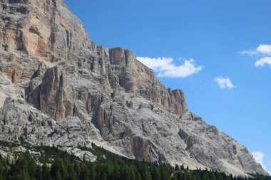 Val Badia, Italy-July 17, 2022: The italian Dolomites behind the small village of Corvara in summer days with beaitiful blue sky in the background. Green nature in the middle of the rocks.