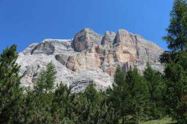 Val Badia, Italy-July 17, 2022: The italian Dolomites behind the small village of Corvara in summer days with beaitiful blue sky in the background. Green nature in the middle of the rocks.