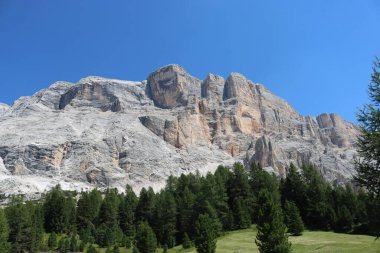Val Badia, Italy-July 17, 2022: The italian Dolomites behind the small village of Corvara in summer days with beaitiful blue sky in the background. Green nature in the middle of the rocks.