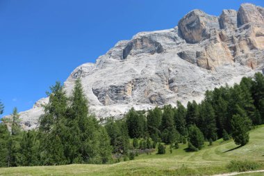 Val Badia, Italy-July 17, 2022: The italian Dolomites behind the small village of Corvara in summer days with beaitiful blue sky in the background. Green nature in the middle of the rocks.