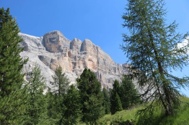 Val Badia, Italy-July 17, 2022: The italian Dolomites behind the small village of Corvara in summer days with beaitiful blue sky in the background. Green nature in the middle of the rocks.