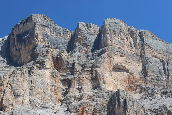 Val Badia, Italy-July 17, 2022: The italian Dolomites behind the small village of Corvara in summer days with beaitiful blue sky in the background. Green nature in the middle of the rocks.