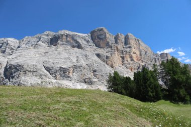 Val Badia, Italy-July 17, 2022: The italian Dolomites behind the small village of Corvara in summer days with beaitiful blue sky in the background. Green nature in the middle of the rocks.