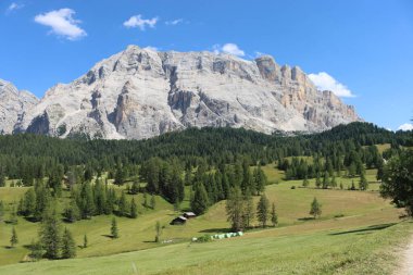 Val Badia, Italy-July 17, 2022: The italian Dolomites behind the small village of Corvara in summer days with beaitiful blue sky in the background. Green nature in the middle of the rocks.