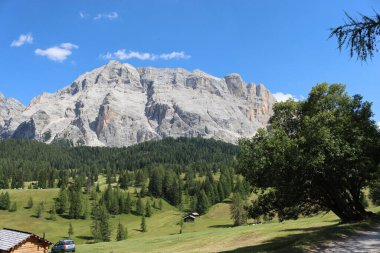 Val Badia, Italy-July 17, 2022: The italian Dolomites behind the small village of Corvara in summer days with beaitiful blue sky in the background. Green nature in the middle of the rocks.