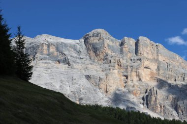 Val Badia, Italy-July 17, 2022: The italian Dolomites behind the small village of Corvara in summer days with beaitiful blue sky in the background. Green nature in the middle of the rocks.