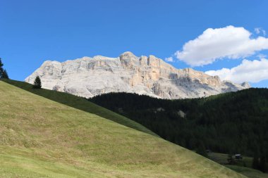 Val Badia, Italy-July 17, 2022: The italian Dolomites behind the small village of Corvara in summer days with beaitiful blue sky in the background. Green nature in the middle of the rocks.