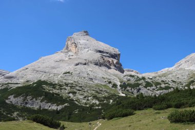Val Badia, Italy-July 18, 2022: The italian Dolomites behind the small village of Corvara in summer days with beaitiful blue sky in the background. Green nature in the middle of the rocks.