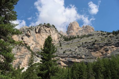Val Badia, Italy-July 18, 2022: The italian Dolomites behind the small village of Corvara in summer days with beaitiful blue sky in the background. Green nature in the middle of the rocks.