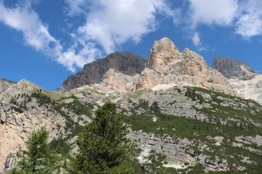 Val Badia, Italy-July 18, 2022: The italian Dolomites behind the small village of Corvara in summer days with beaitiful blue sky in the background. Green nature in the middle of the rocks.